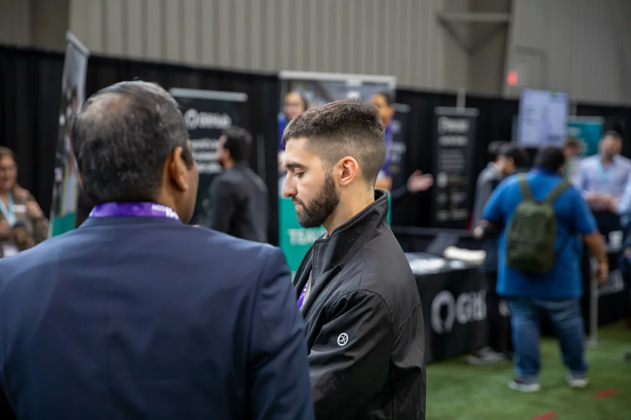 Attendees connecting in the technology exhibition area